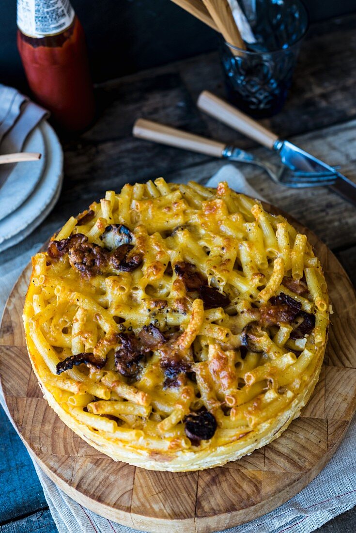 Macaroni cheese cake on a wooden board