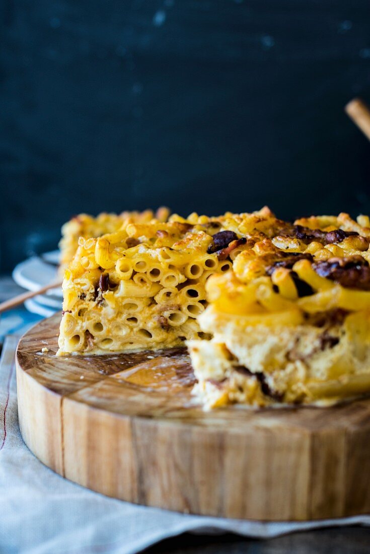 Slices of macaroni cheese cake on a wooden board