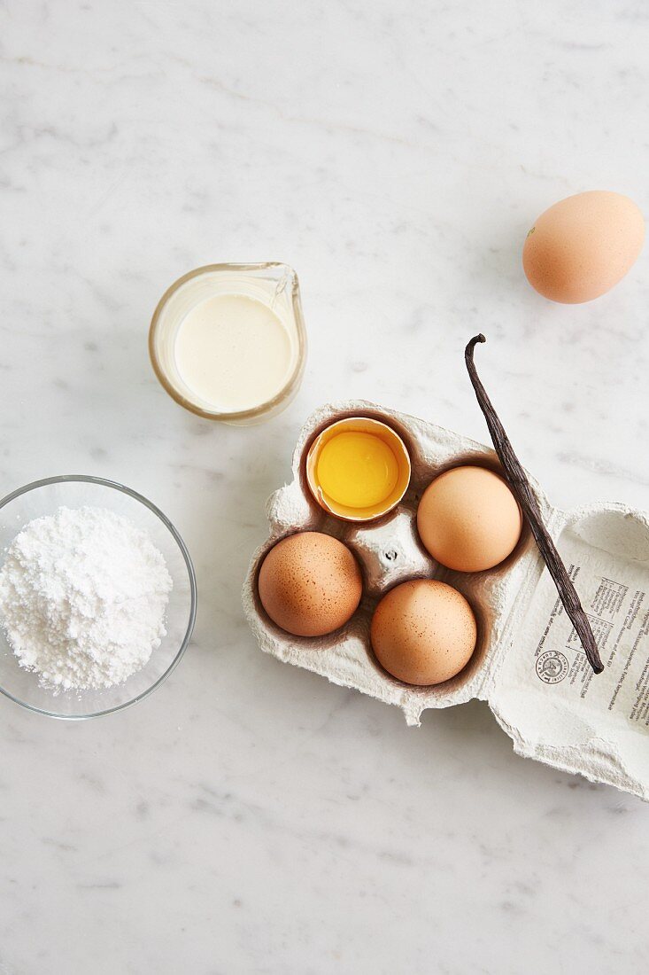 Ingredients for ice cream: cream, egg yolk, icing sugar and vanilla pod