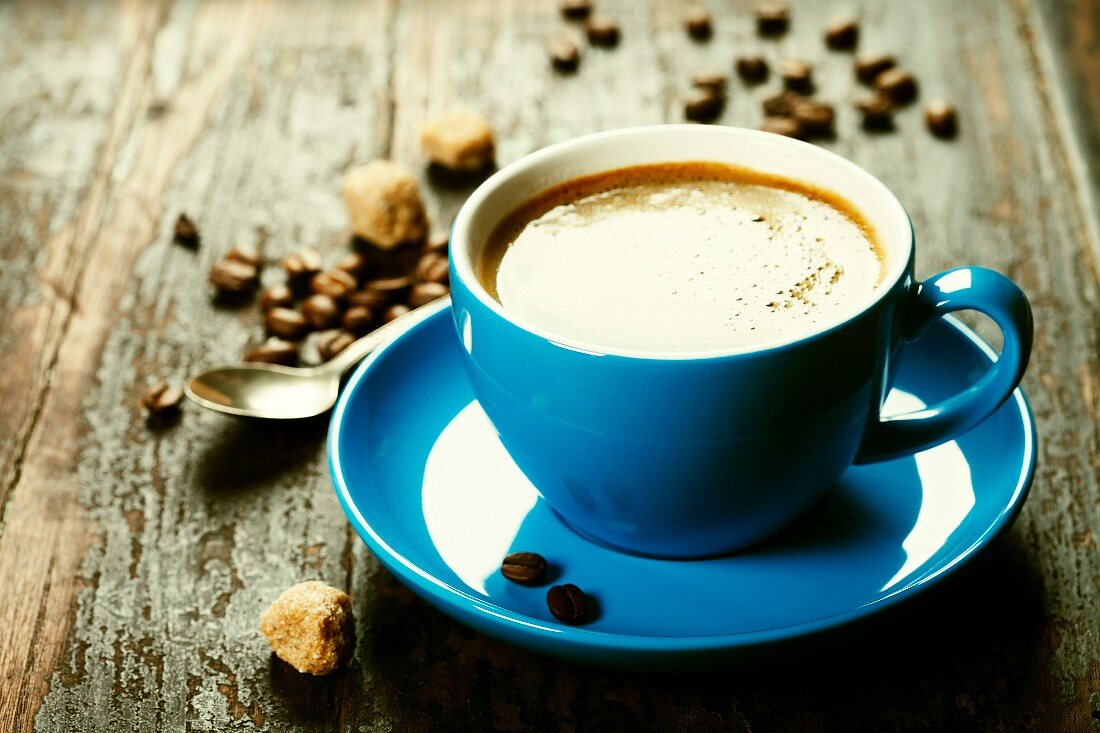 Blaue Tasse mit Kaffee auf Holzuntergrund