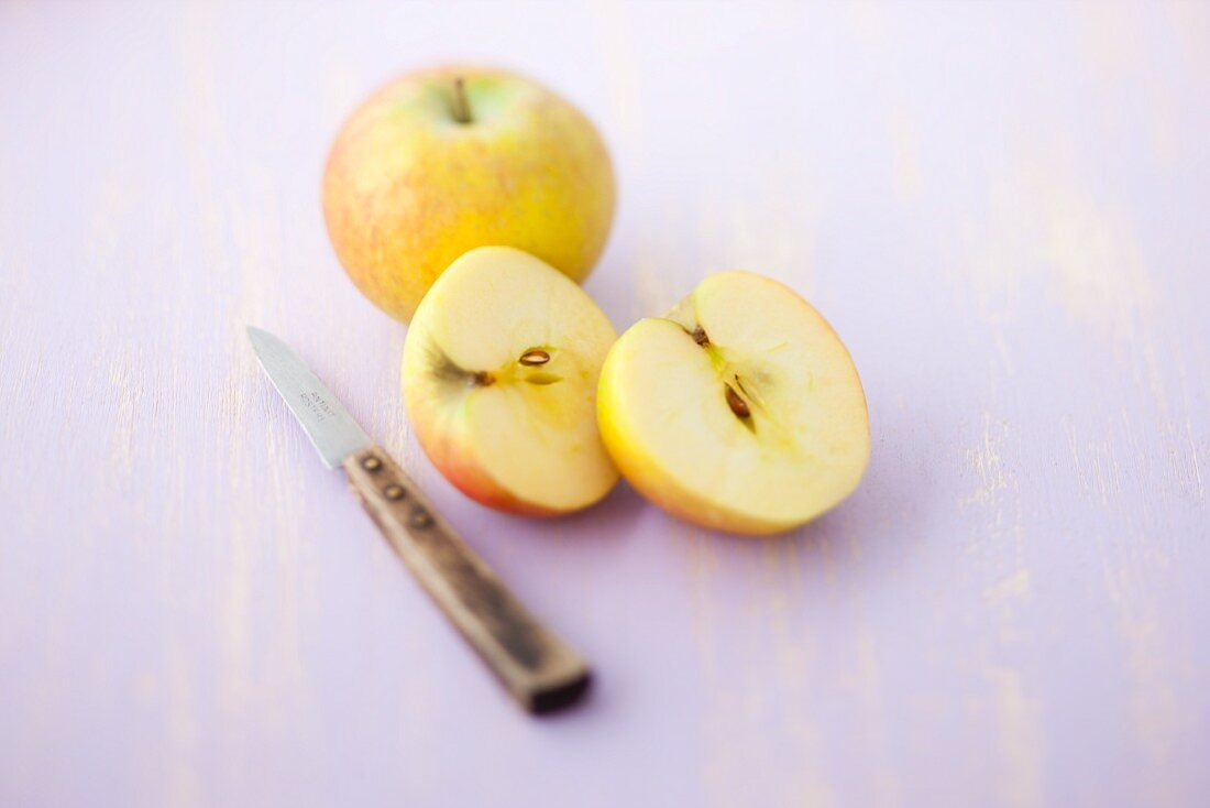 Boskop-Äpfel, ganz und halbiert, mit Messer