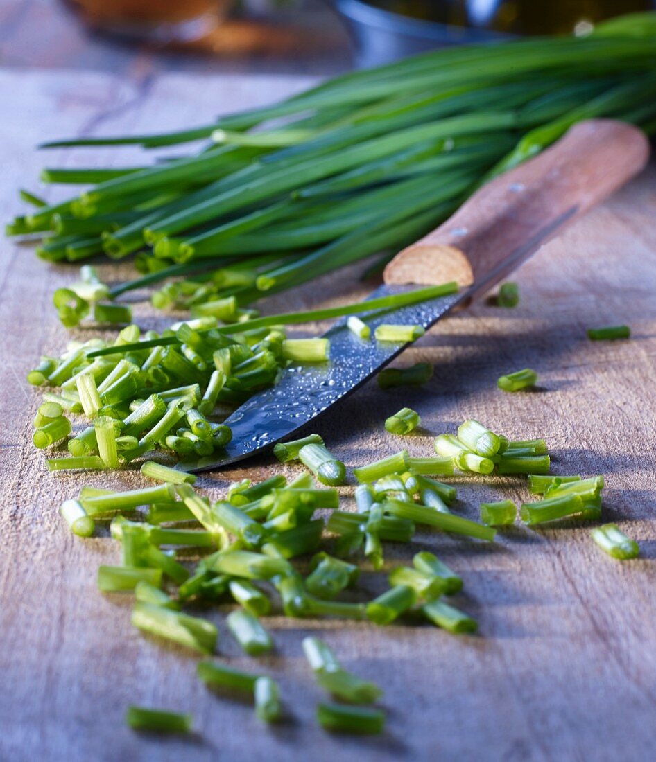 Cutting chives on a wooden board