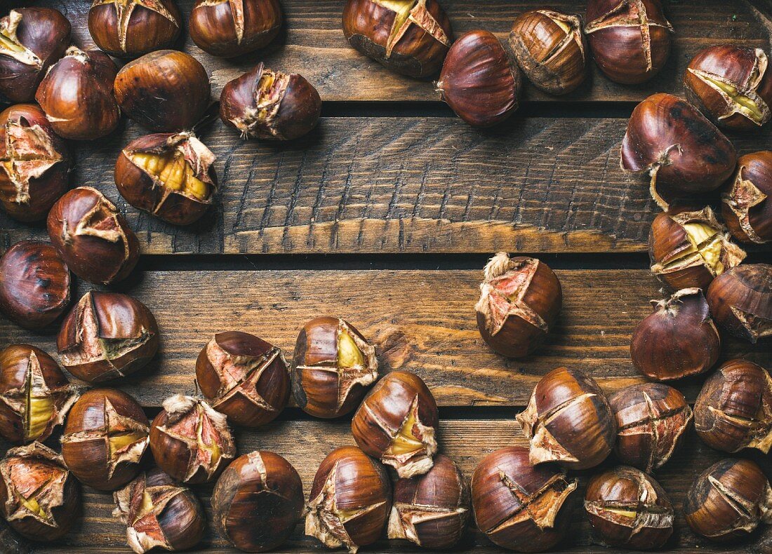 Roasted chestnuts over rustic wooden table background