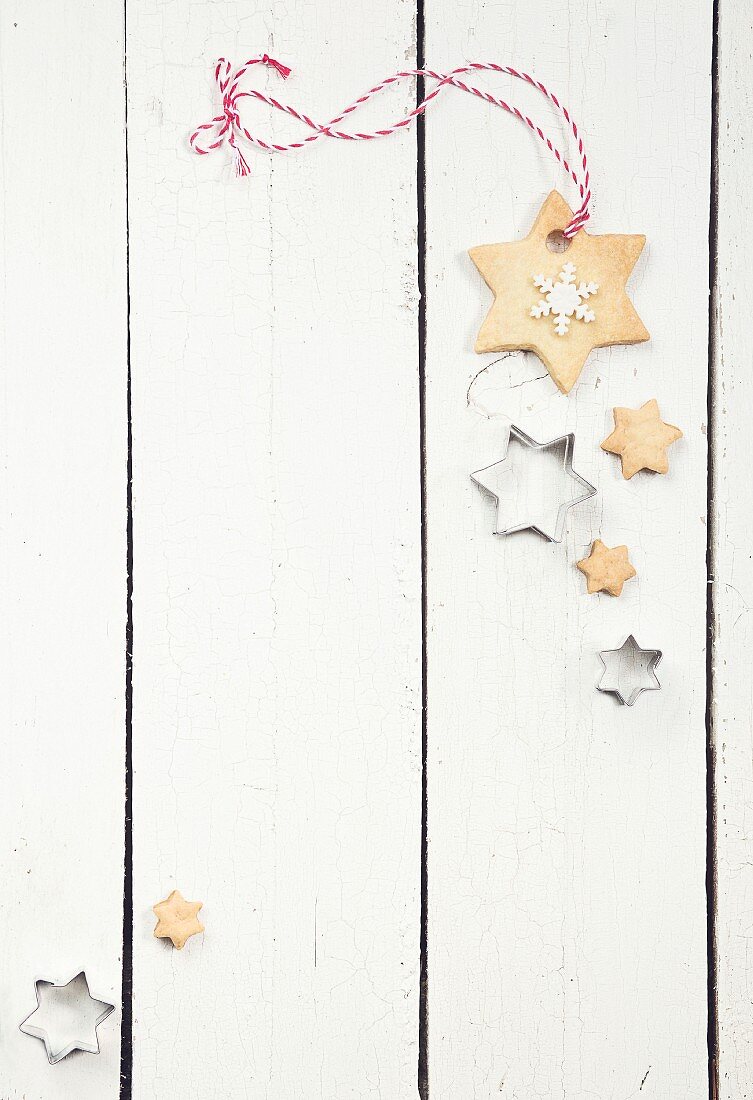 Sternförmige Weihnachtsplätzchen auf weißem Holzuntergrund
