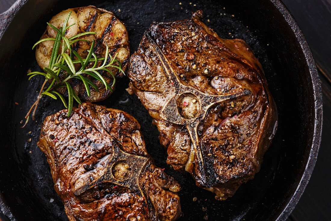 Roasted lamb loin chops with rosemary and garlic on iron pan