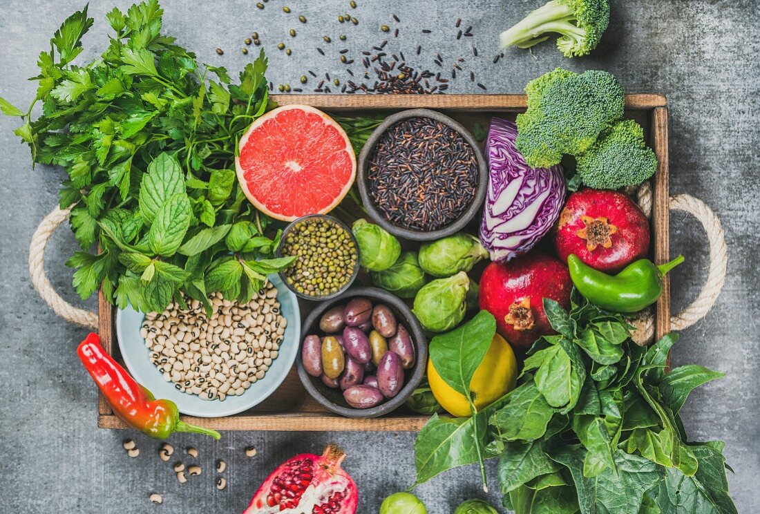 Superfood-Stillleben mit Gemüse, Obst, Samen, Getreide, Bohnen, Gewürzen und Kräutern in Holzkiste