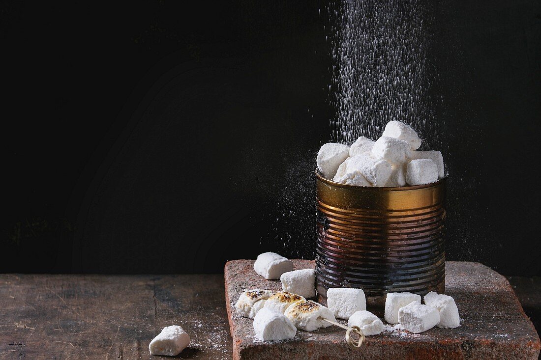 Vanille-Marshmallows in Metalldose werden mit Puderzucker bestreut