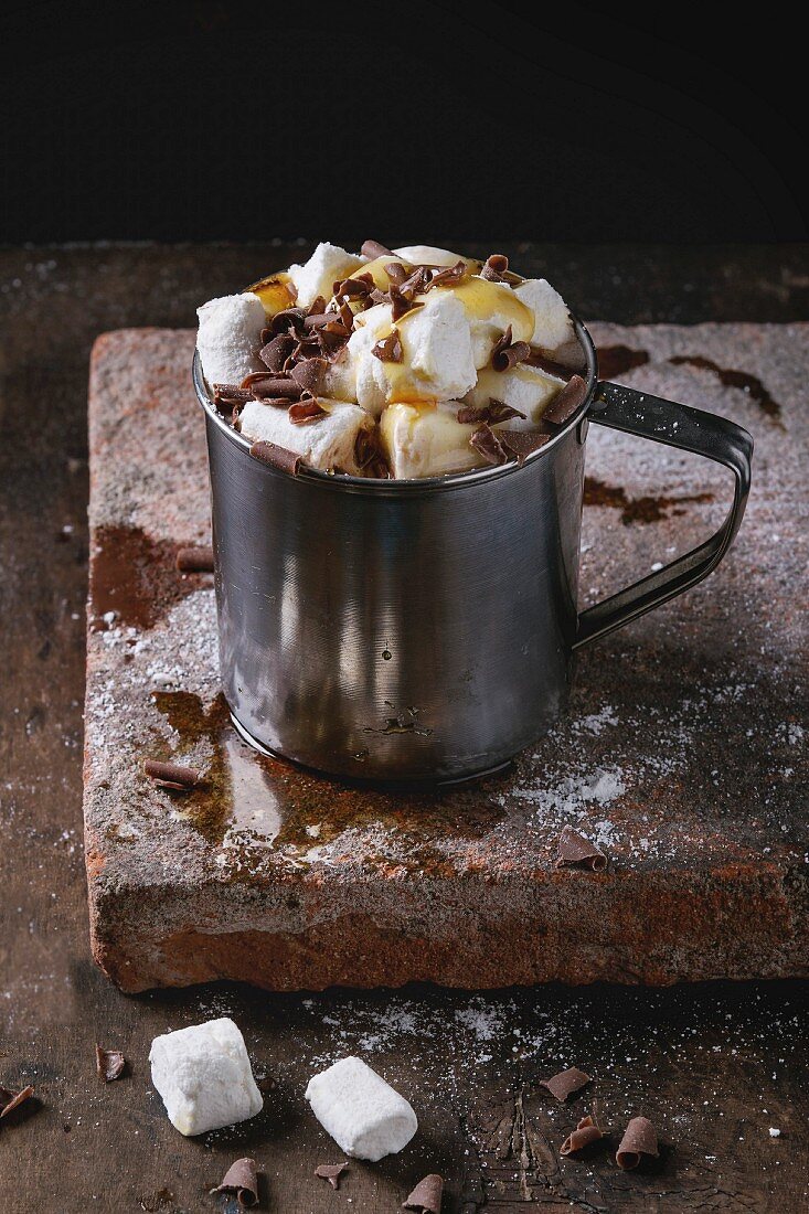 Heiße Schokolade mit Marshmallows, Schokoraspeln und Sirup in Metallbecher