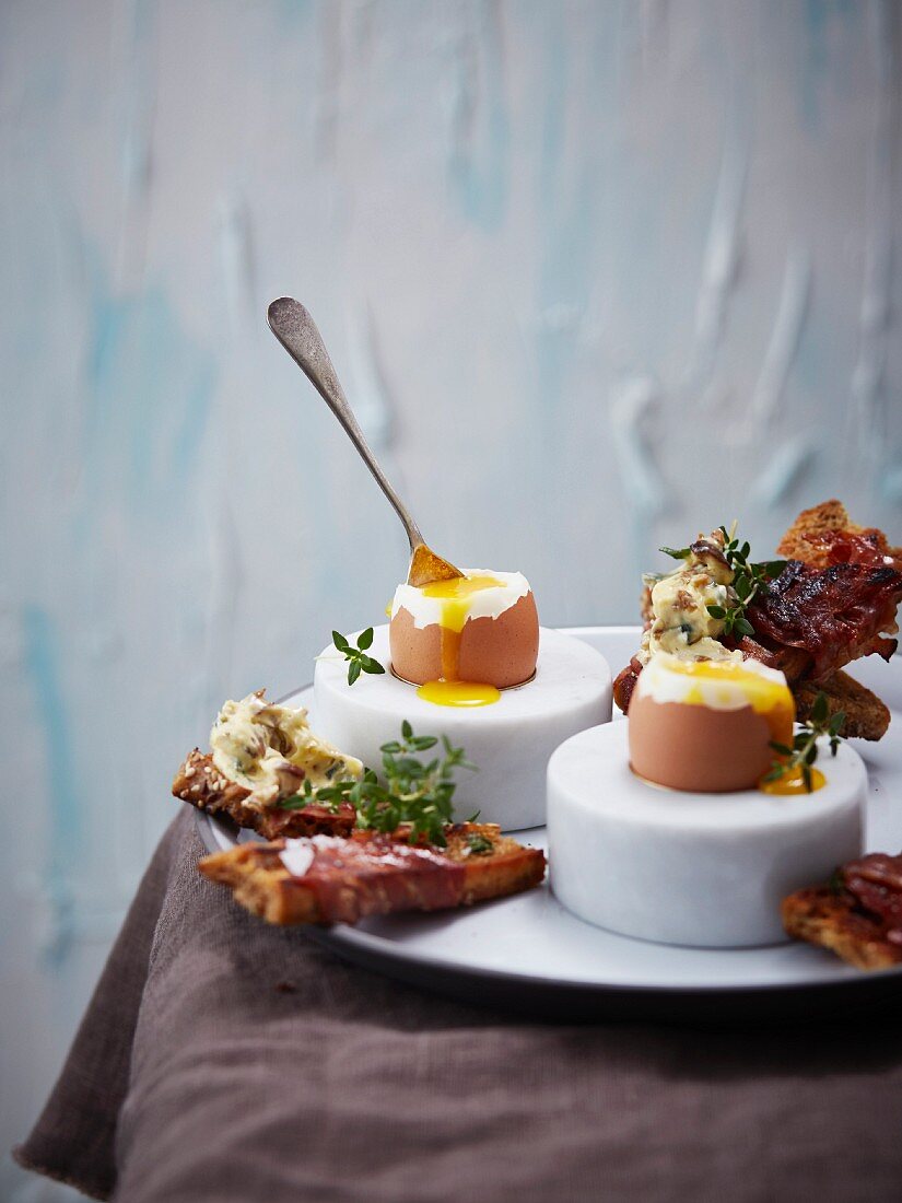 Soft-boiled eggs with ham, bread and porcini mushroom butter