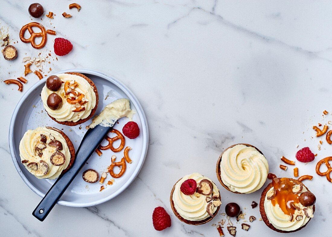 Cracker und Salzbrezeln mit Sahnecreme, Himbeeren und Schokonüssen