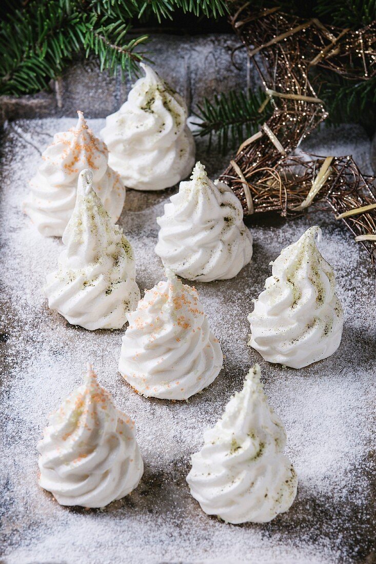 Homemade white french meringue as Christmas fir tree decorated by colored sugar and matcha tee