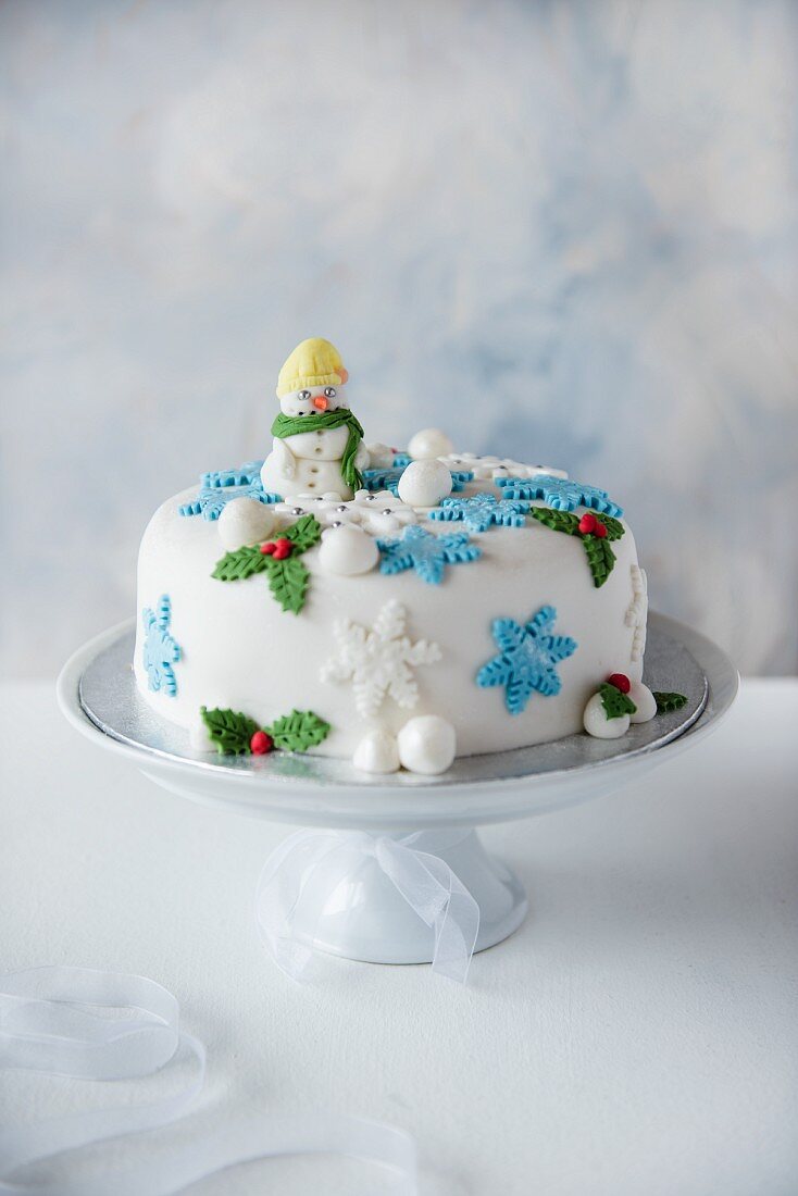 A Christmas cake on a white cake stand