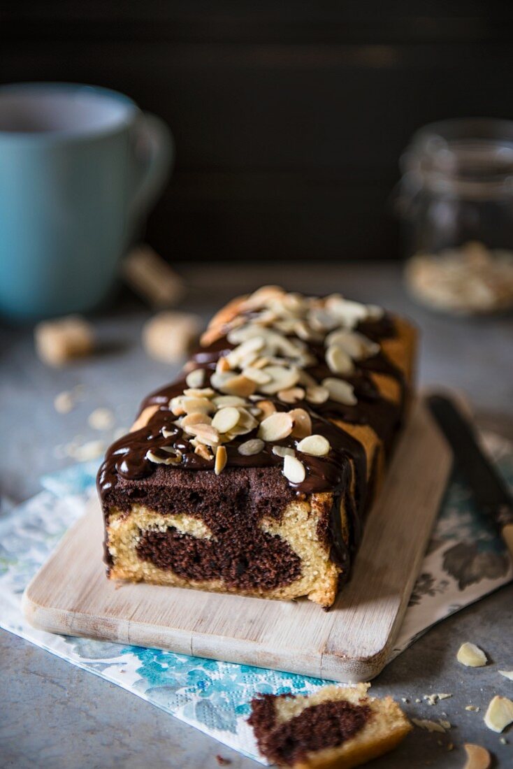 Marble cake with chocolate glaze and flaked almonds