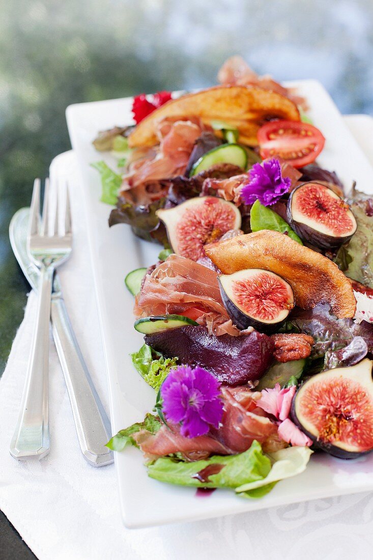 A salad with pears poached in red wine, halloumi, pecans and Parma ham