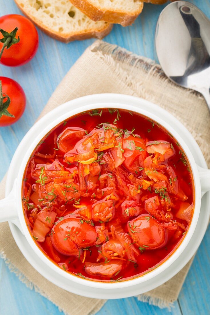 Vegetable soup made of cherry tomatoes, carrot, potato, cabbage in a bowl