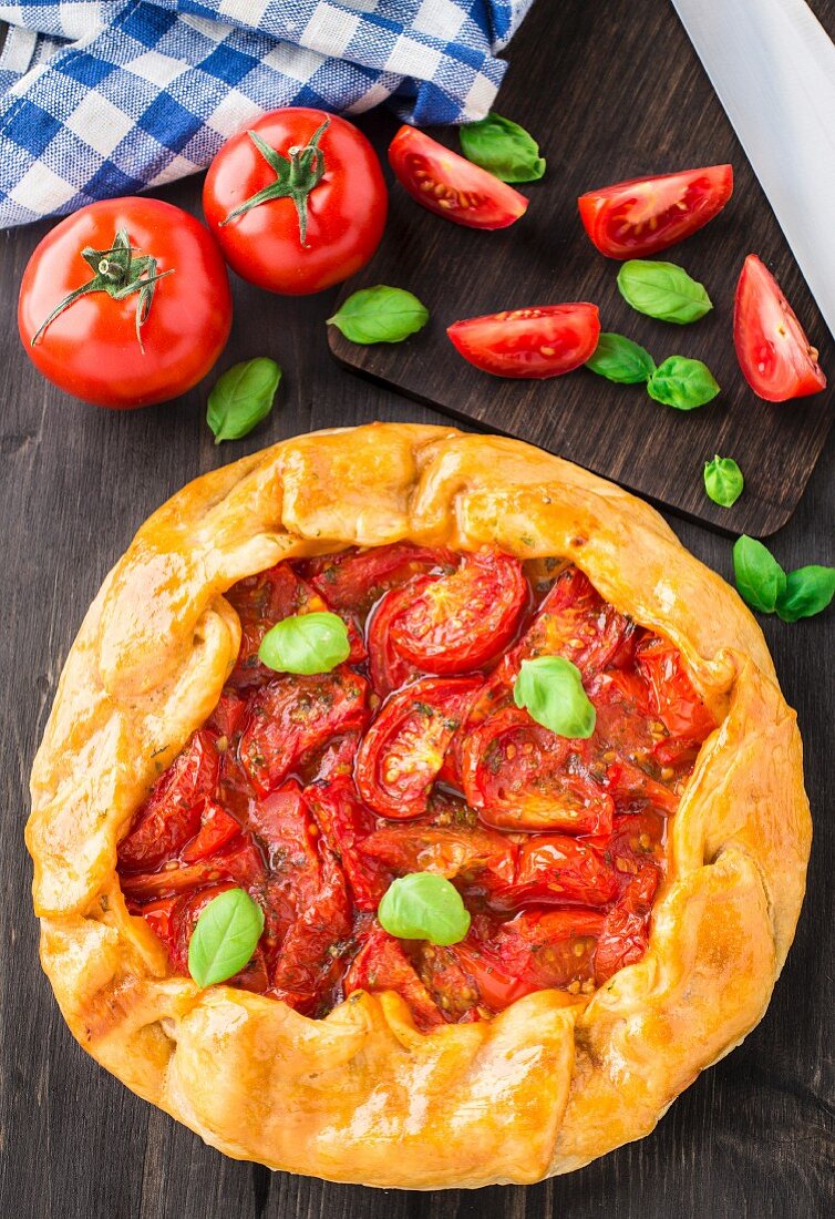 Galette with tomato and basil on a table