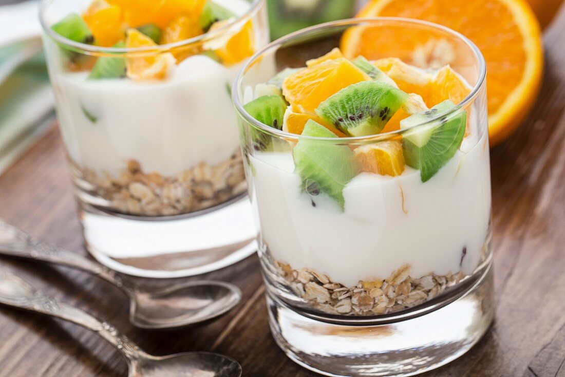 Yogurt with muesli, kiwi and orange in a glass