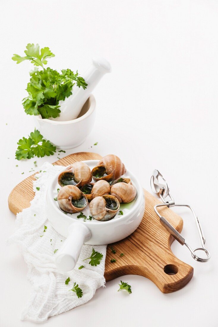 Baked snails with garlic butter sauce and fresh greens