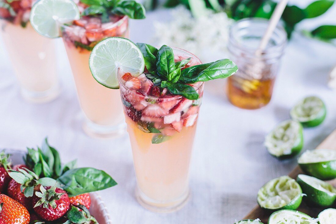 Honig gesüsste Limeade in Gläsern mit Erdbeeren und Basilikum