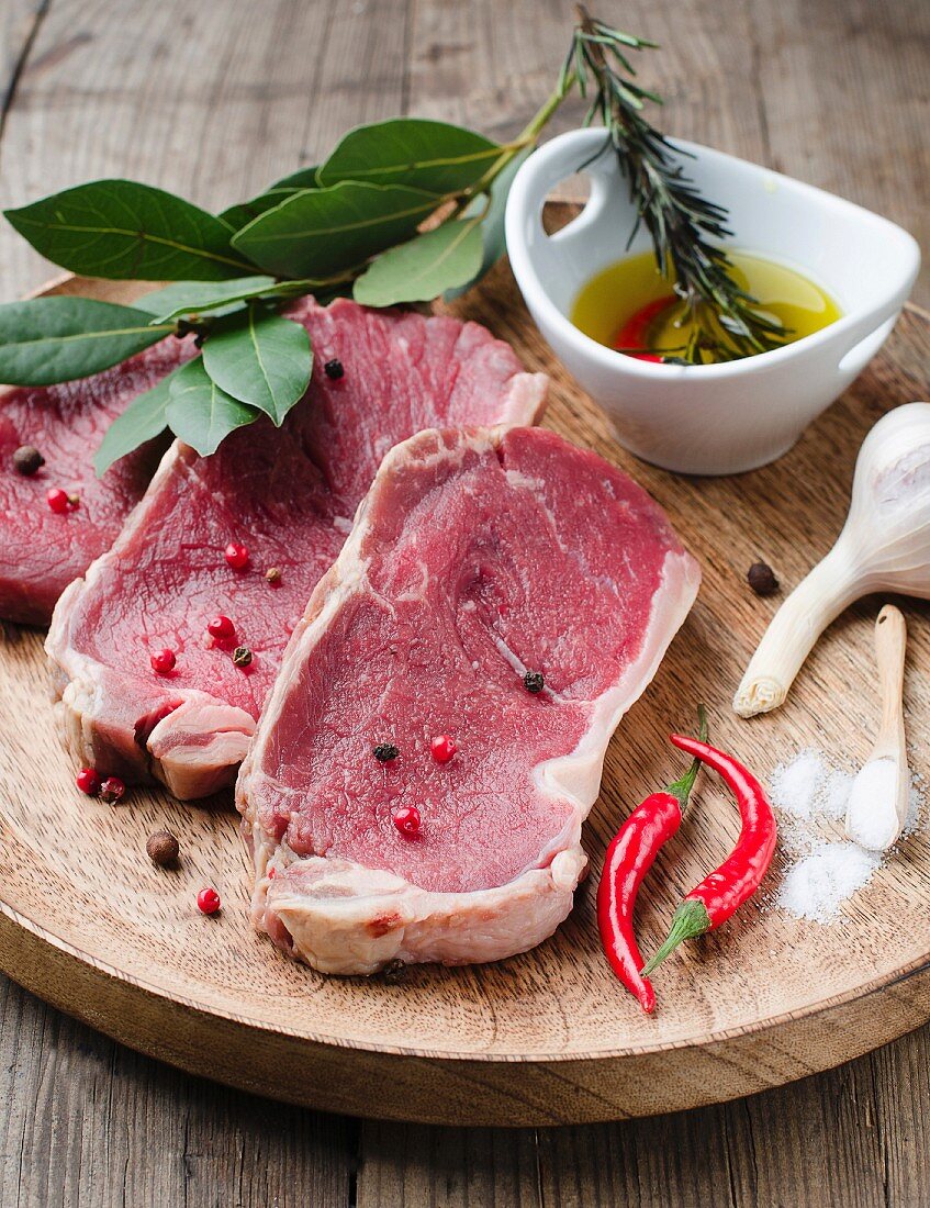 Rohe Rindersteak mit Gewürzen auf Holzbrett