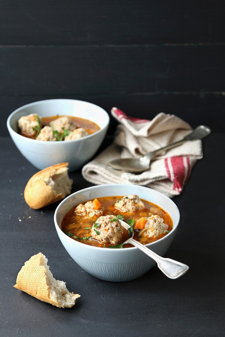 Meatballs soup in a bowl on black background