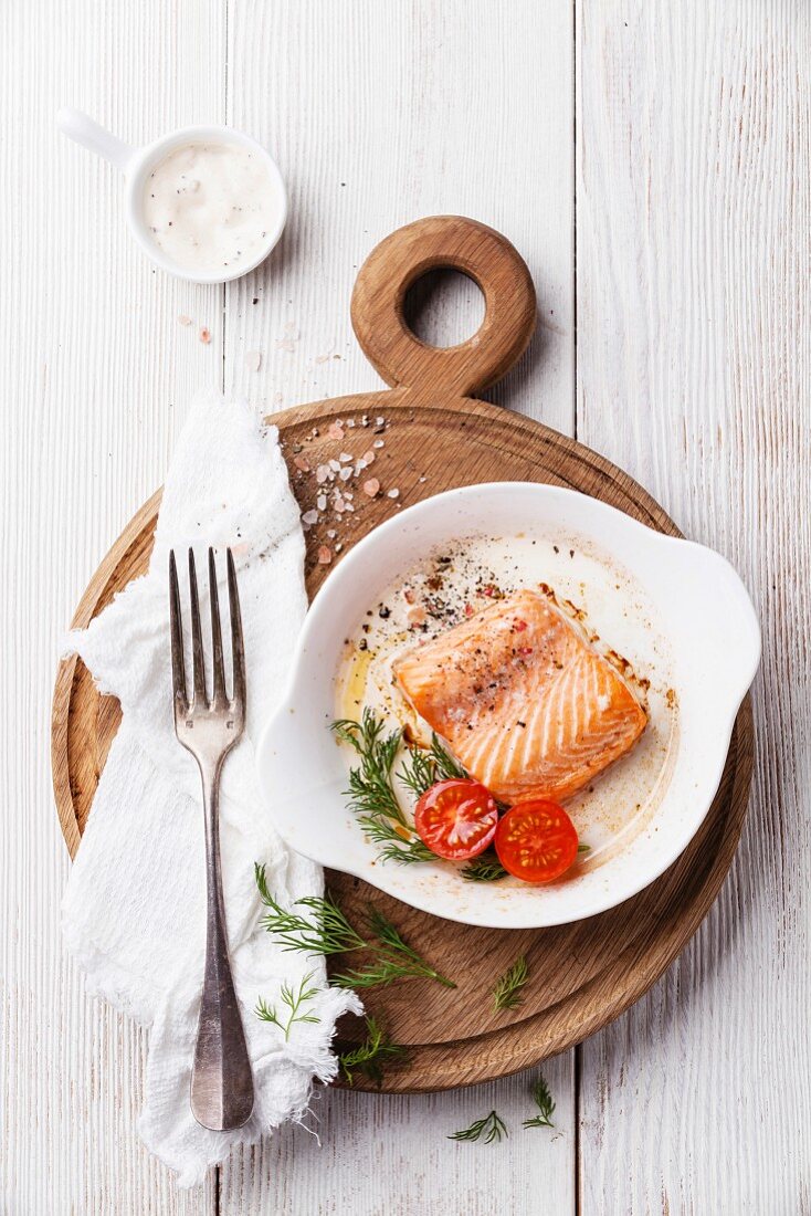 Baked salmon in a bowl on a wooden board