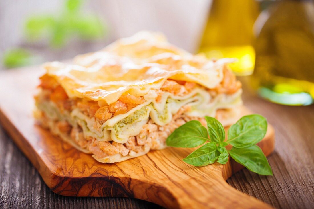 Fisch- und Brokkoli-Mousse Lasagne auf einem Holzbrett