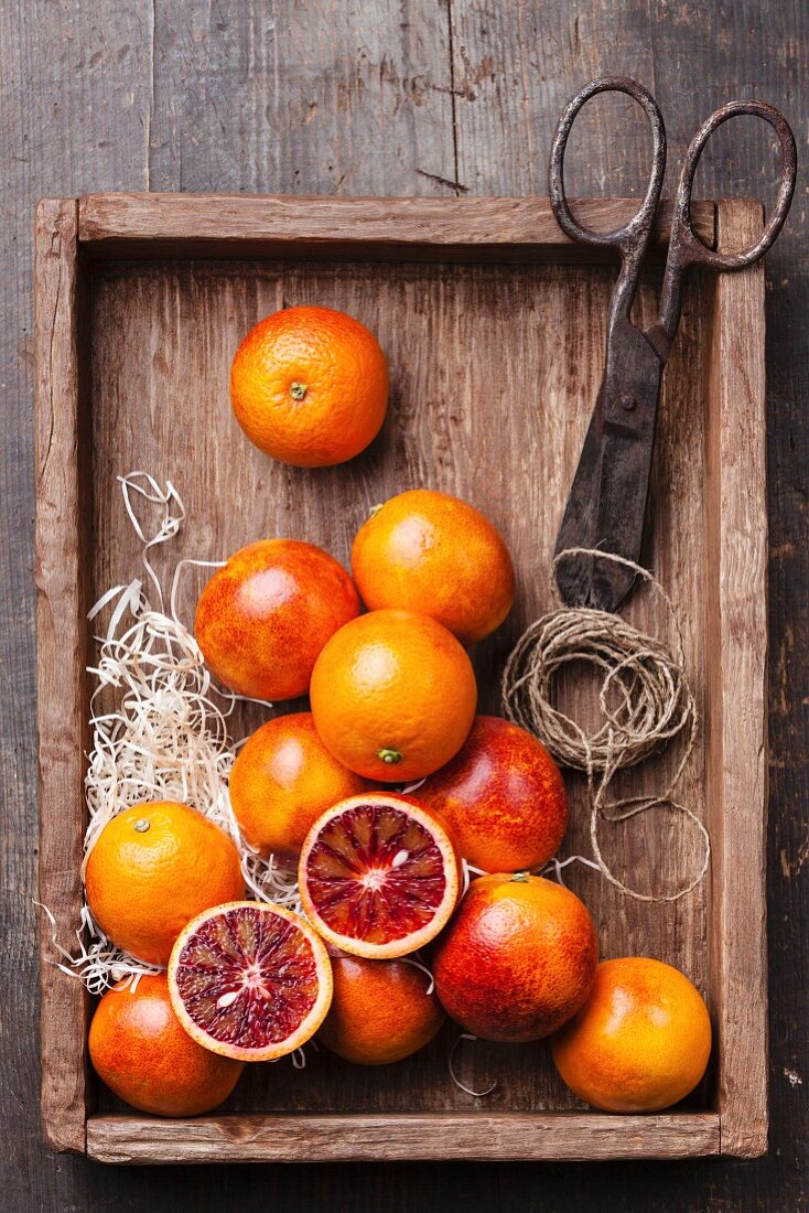 Ripe red oranges on textured wooden background