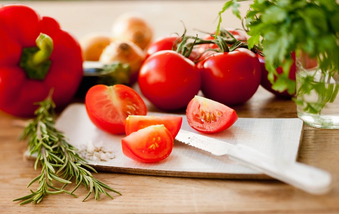 Stillleben mit Tomaten, Rosmarin und Paprika