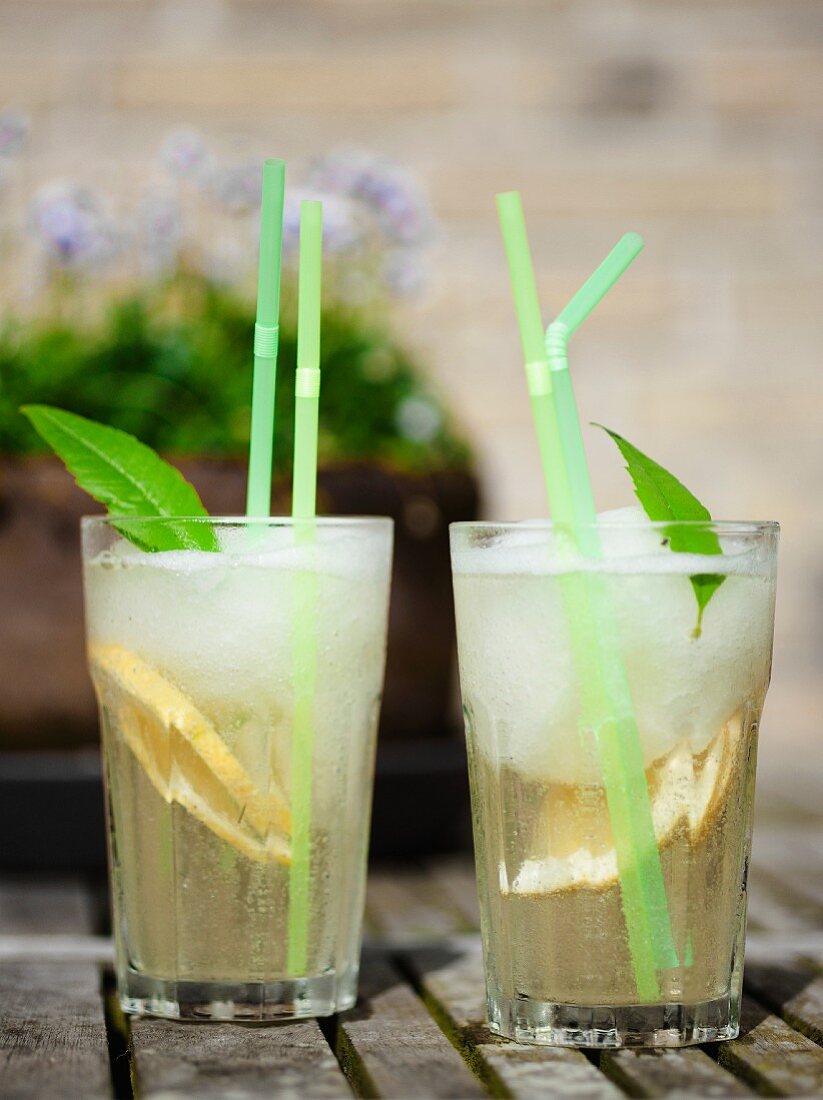 Two glasses of lemonade with mint and straws