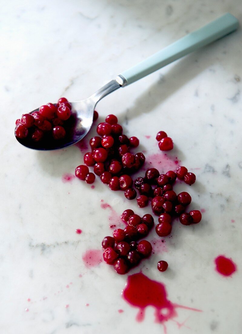 Preiselbeeren mit Löffel auf Marmorplatte