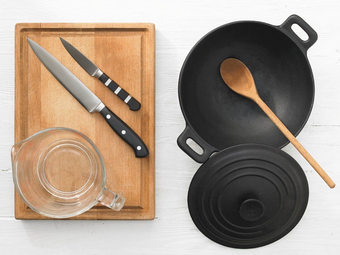Various kitchen utensils: wok, cooking spoon, knife, measuring cup