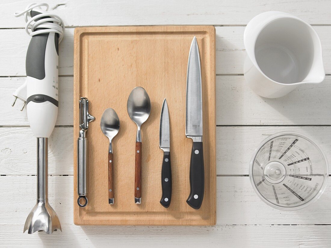 Various kitchen utensils: blender, peeler, spoons, knives, mixing jug, measuring cup