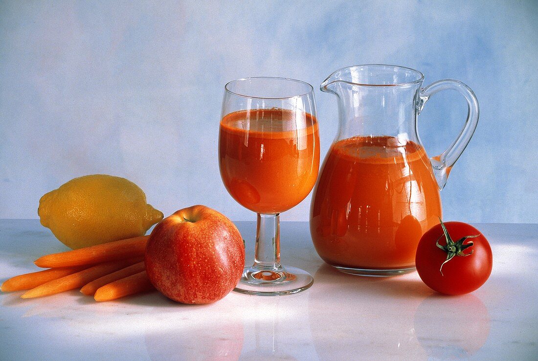Vegetable Juice From Carrots and Tomato in a Pitcher and Glass