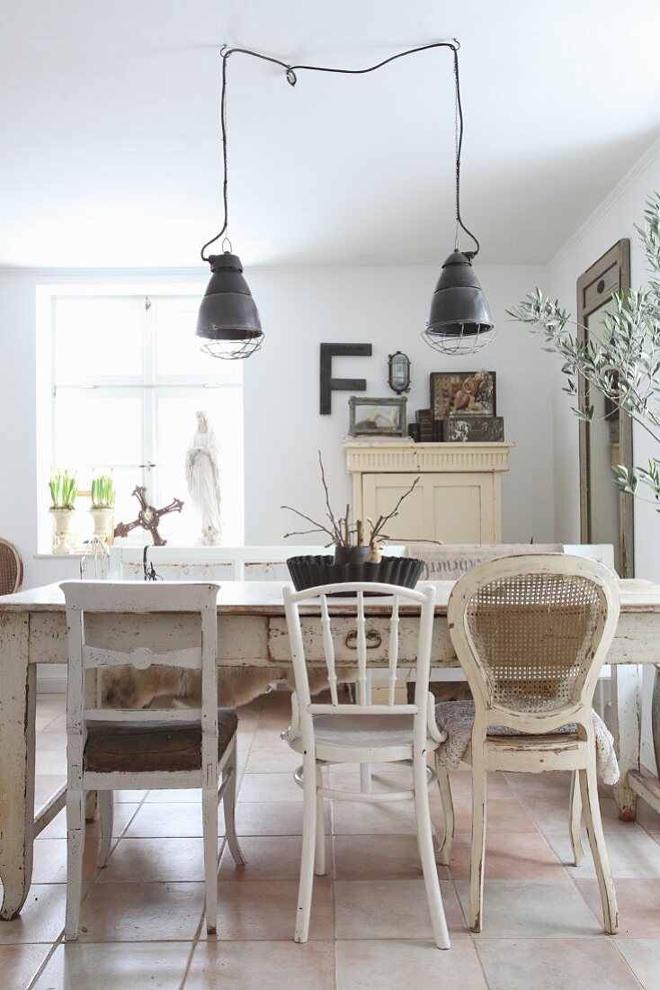 Various white chairs around old wooden table