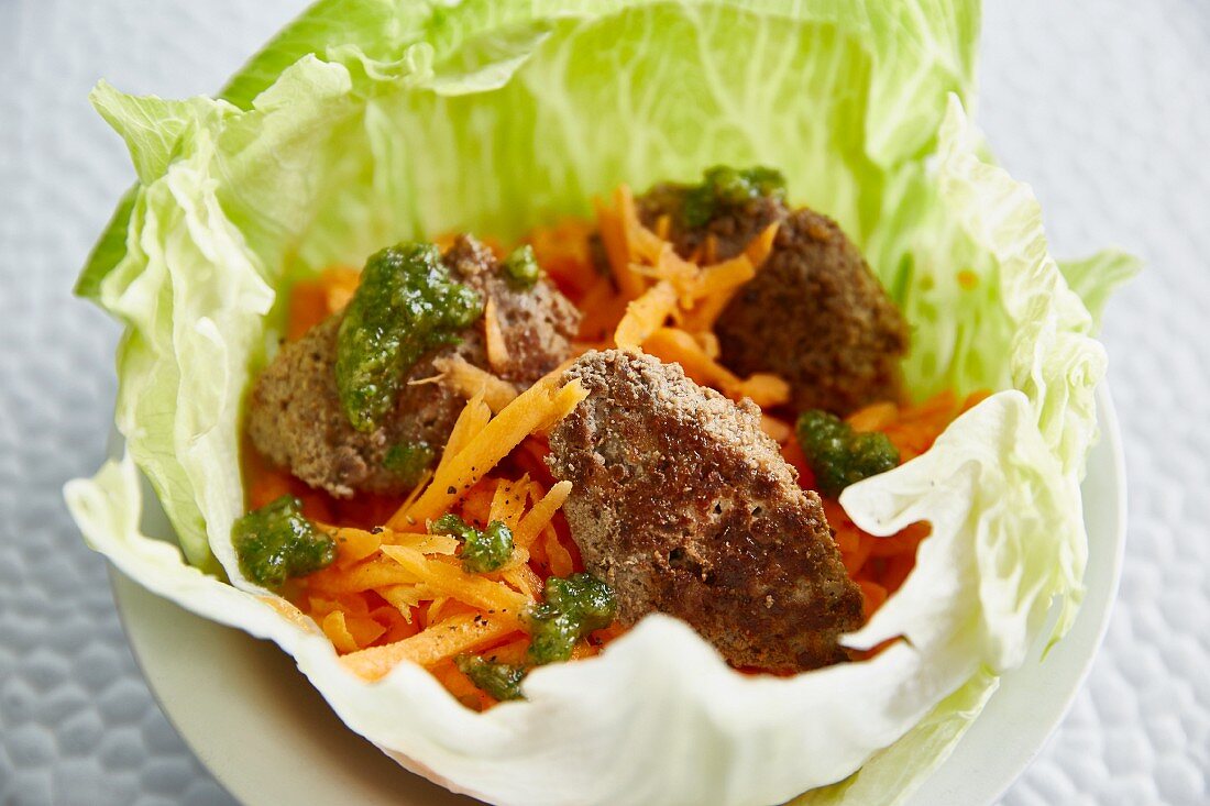 A salad bowl with meatballs and grated carrot