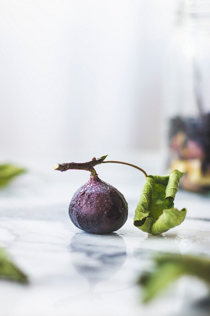 Eine frische Feige mit Blatt auf Marmoruntergrund