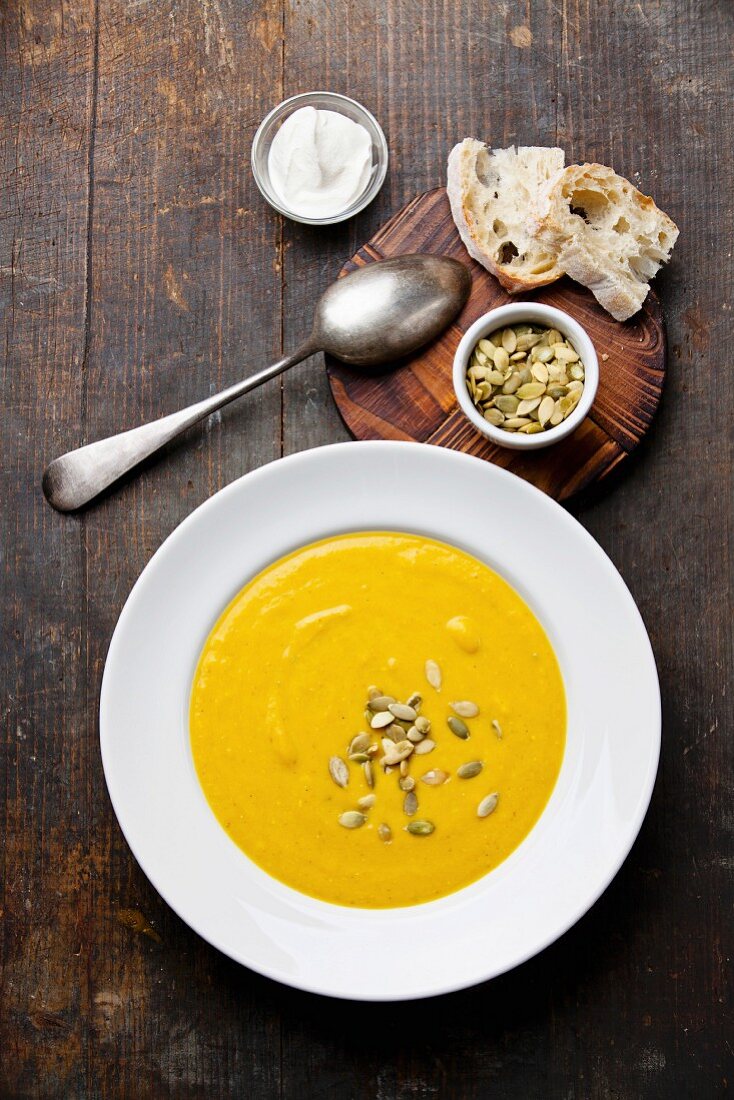 Pumpkin soup with pumpkin Seeds on wooden background