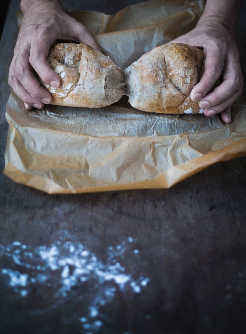Hände halten frisch gebackenes Schweizer Brot