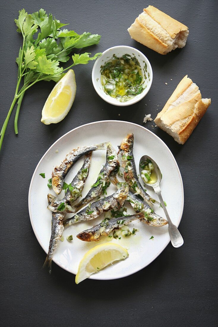 Grilled sardine with salsa verde on a plate