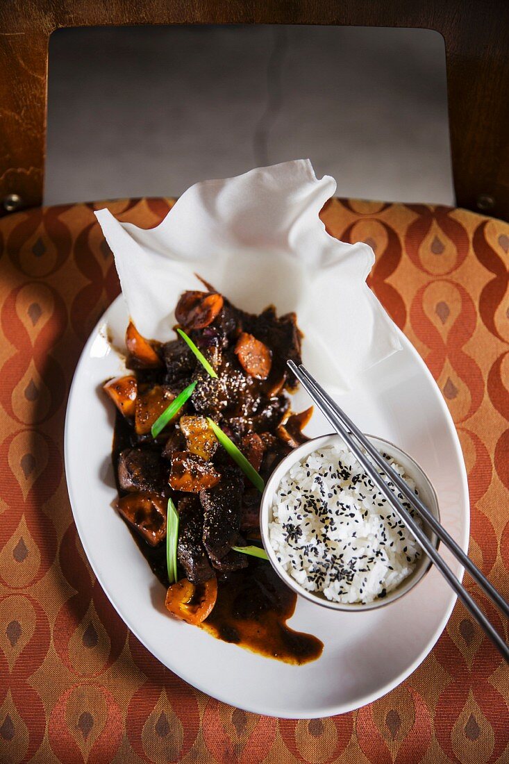 Asian dish - beef in black pepper sauce, with rice, shot on vintage chair