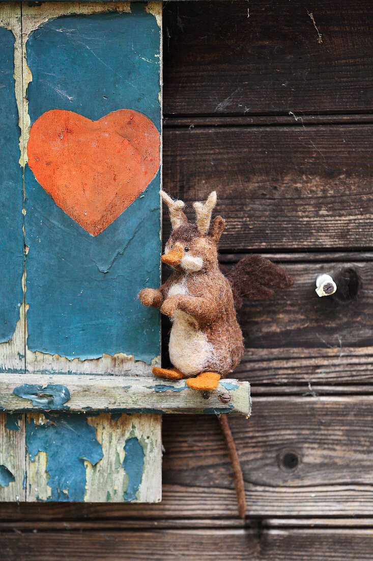 Hand-made, felted, woollen wolpertinger against wooden background