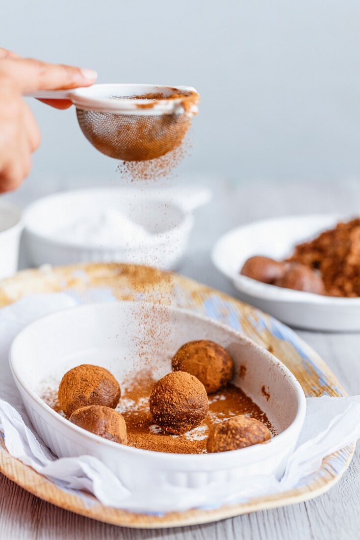 Lady dusting Cocoa on Cake Crumble Chocolate Truffles