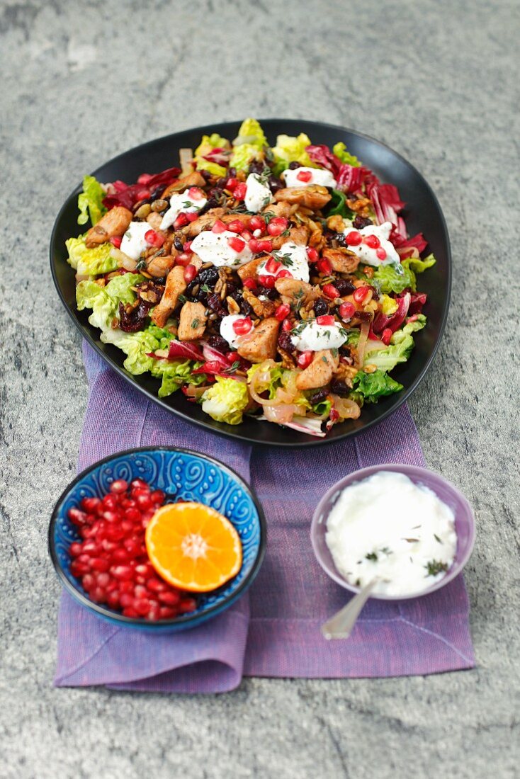 Salat mit Hähnchen, Nüssen, getrockneten Preiselbeeren, Granatapfel und Joghurt