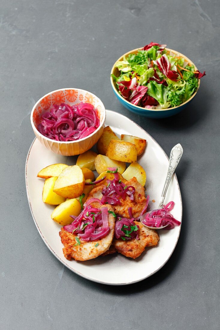 Pork schnitzel with caramelized onion and baked potatoes
