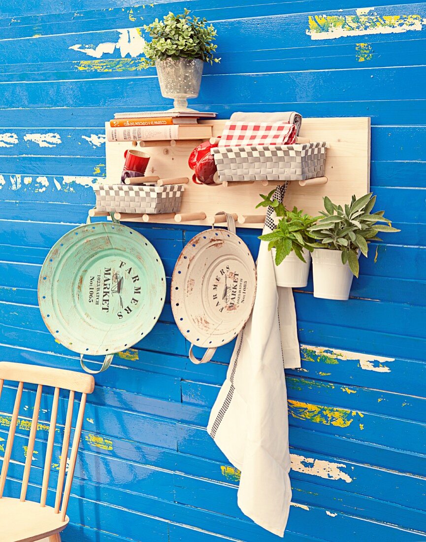 Hand-crafted, wall-mounted shelf with wooden pegs for holding baskets, books and various objects