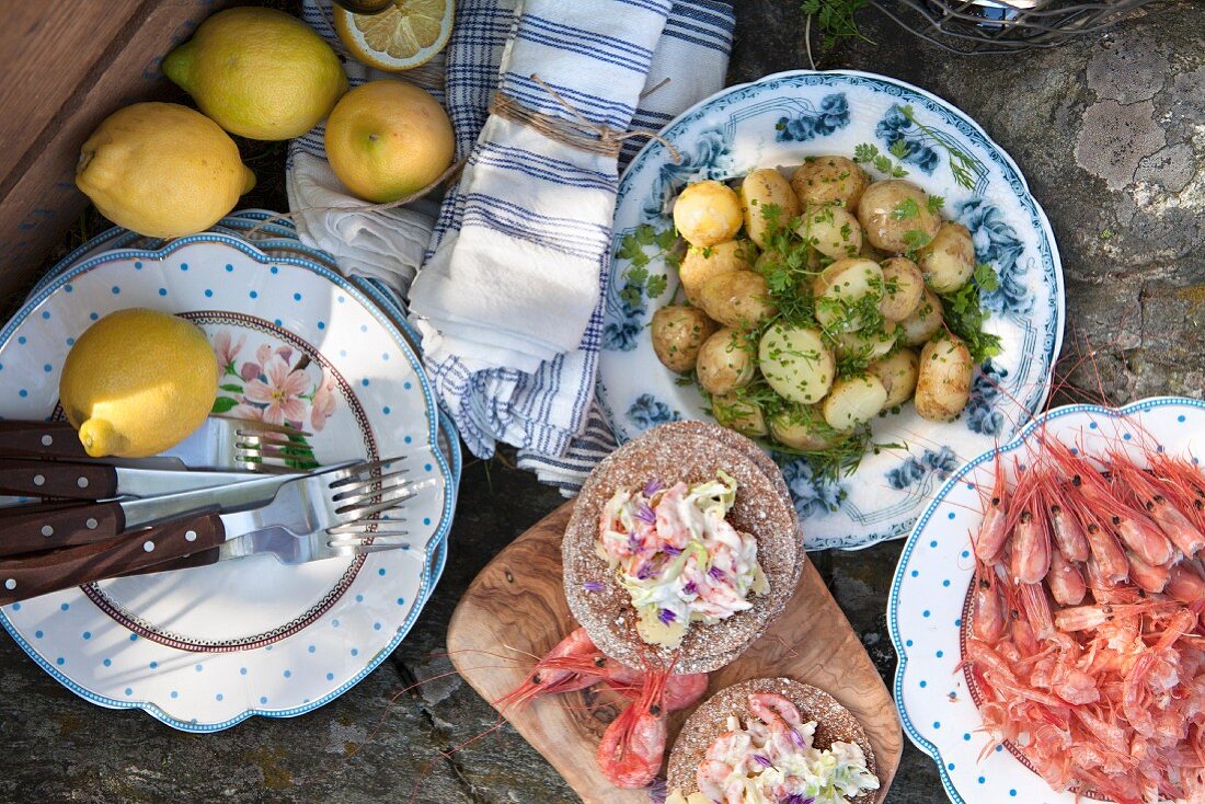 Buffet im Freien mit Kartoffeln, Garnelen und Zitrone