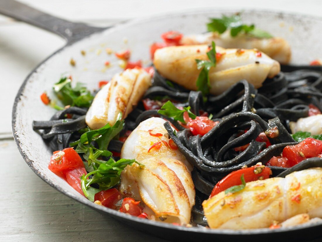 Schwarze Pasta mit Tintenfisch und Tomaten