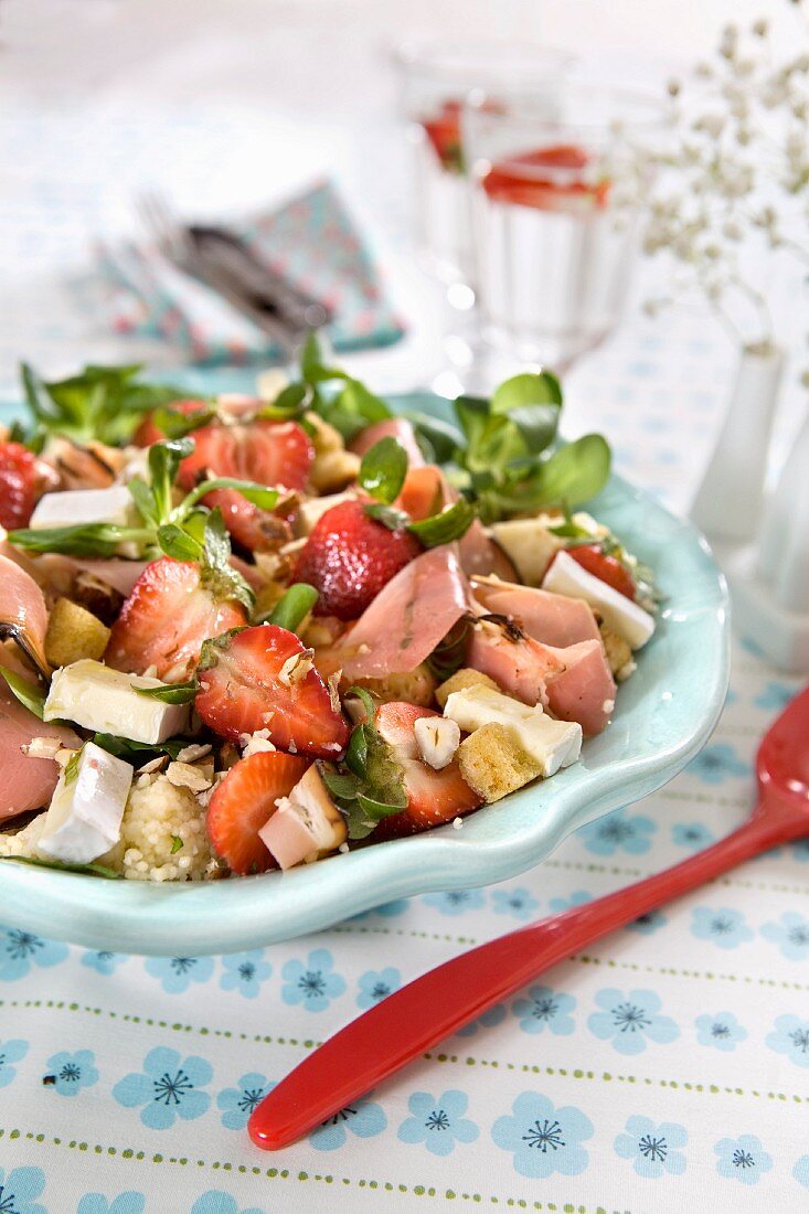 Salat mit Couscous, Erdbeeren, Käse, Croûtons, Haselnüssen und Schinken