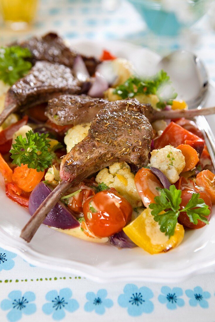 Grilled lamb chops with lettuce, vegetables, tomatoes, cauliflower, carrots, red onion, pepper and parsley
